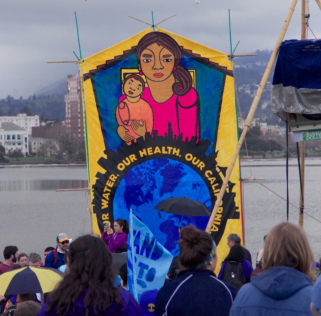 Banner at Oakland march: we must divest!